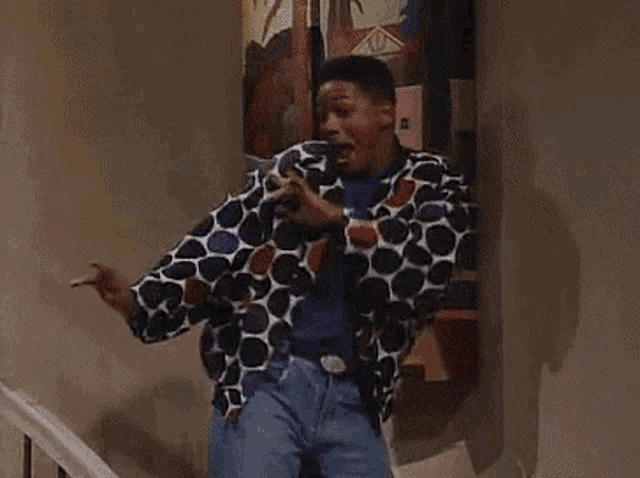 a man wearing a polka dot jacket is standing on a set of stairs .
