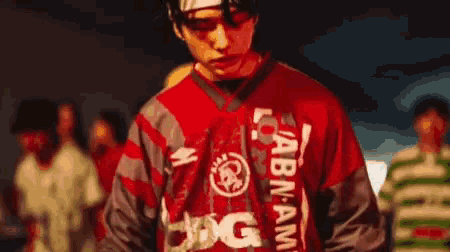 a man wearing a red shirt that says abn am on it