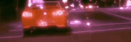 a car is driving down a street at night with purple lights .