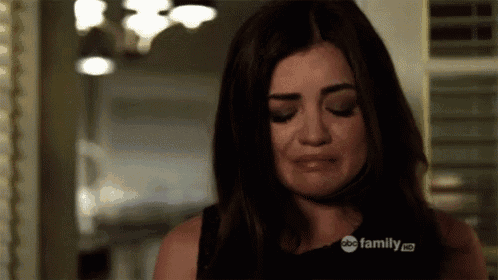 a woman is crying in a room with a abc family logo on her shirt .