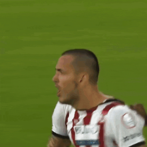 a soccer player with a tattoo on his arm is being tackled by another player
