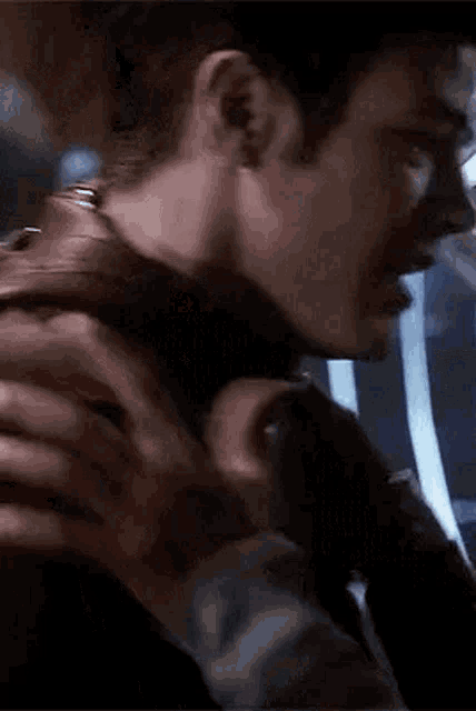 a close up of a man holding another man 's neck in a room .