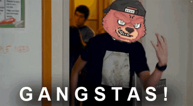 a man wearing a metallica shirt is standing in front of a wall that says gangstas