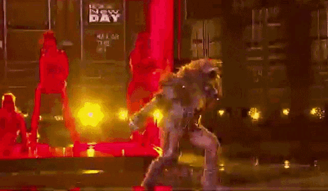 a man is dancing on a stage in front of a sign that says new day