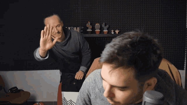 a man giving a high five to another man in front of a sign that says love