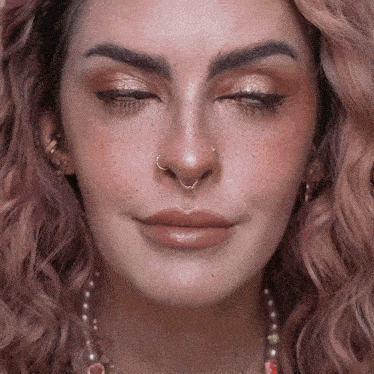 a woman with pink hair has a nose ring on her nose