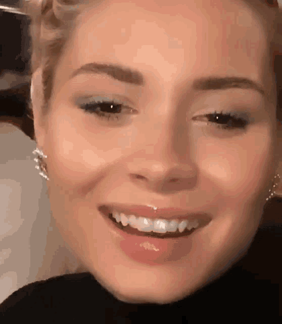a close up of a woman 's face with a smile on it
