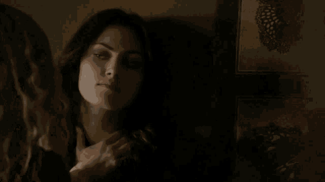 two women are fighting in a dark room in front of a wall with a picture of butterflies on it .