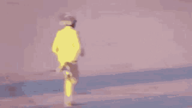 a person in a yellow suit is walking on a pink surface .