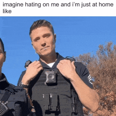 a police officer is wearing a black vest with a small camera on it