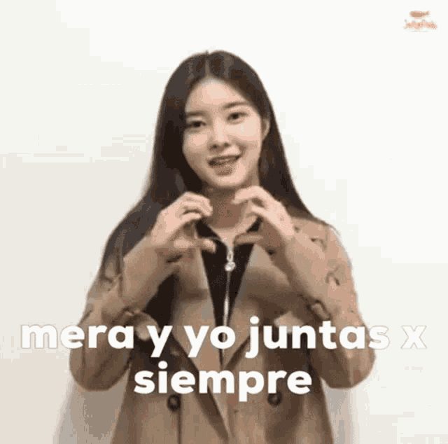 a woman is making a heart shape with her hands and the words mera y yo juntas x siempre are above her