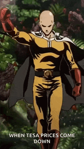 a man in a superhero costume is standing in front of a forest with his arm in the air .