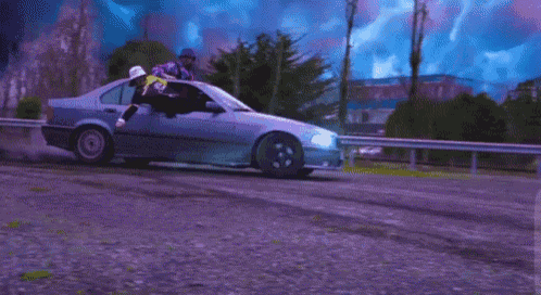 a man in a cowboy hat is driving a car on a road