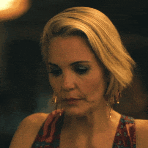 a close up of a woman 's face with earrings on