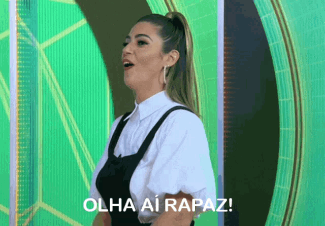 a woman says olha ai rapaz in front of a green screen
