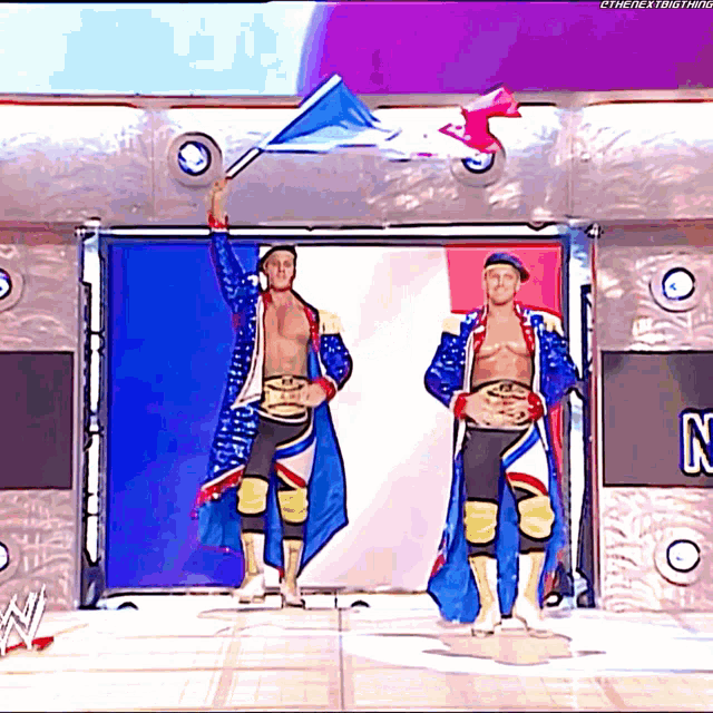 two wrestlers are standing in front of a sign with the letter n on it
