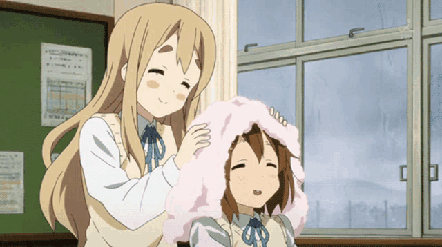 two anime girls are standing in front of a window and one has a pink blanket on her head
