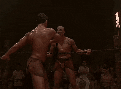 two men are wrestling in a ring with flames coming out of their mouths