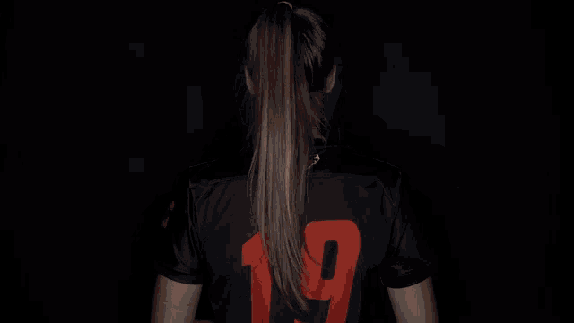 a girl with her arms crossed wearing a campbell jersey