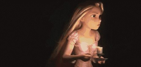 rapunzel from tangled is holding a candle in the dark .