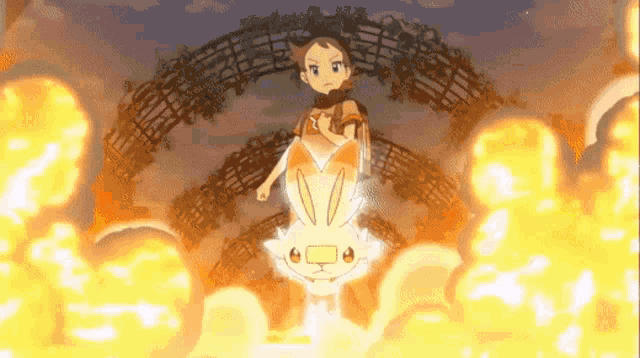 a girl is standing next to a rabbit that is surrounded by fire .