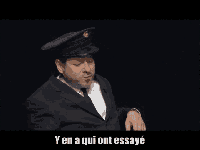 a man in a suit and hat with the words yen a qui ont essaye on the bottom
