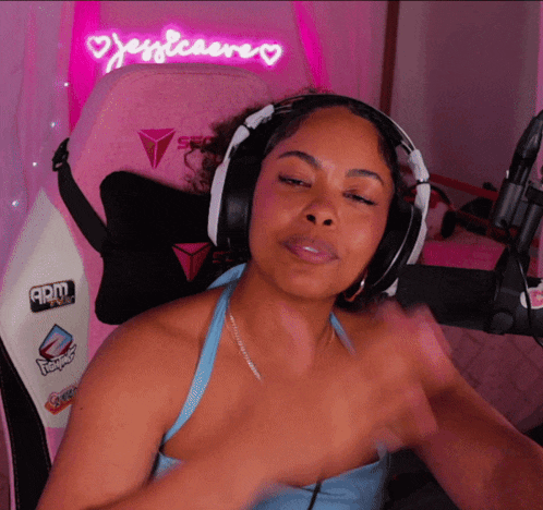 a woman wearing headphones is sitting in front of a pink chair with the name jessleaere written on it