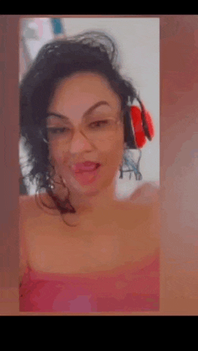 a woman wearing glasses and headphones is making a funny face .