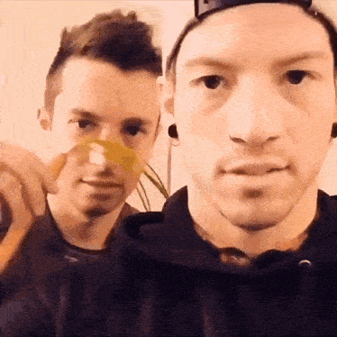two men are standing next to each other and one is wearing an oxygen mask on his face .