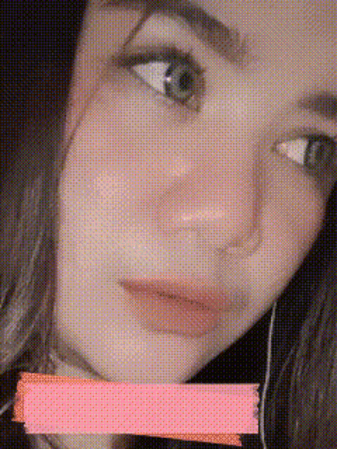 a close up of a woman 's face with a pink sticker on her mouth