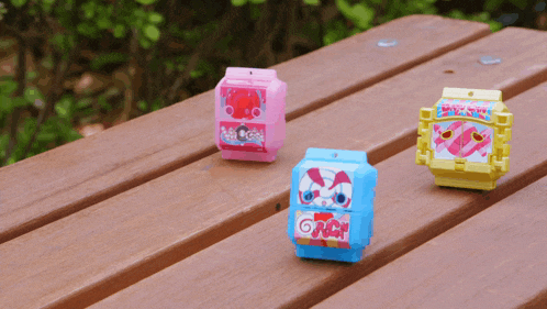 three toys on a wooden table one of which has the word nc on it