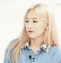 a woman with blonde hair is wearing a blue shirt and a microphone .
