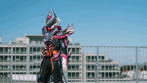 a person in a pink and black costume is standing on a balcony holding a gun