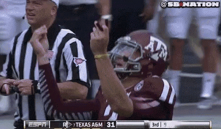a football player wearing a texas a & m helmet is celebrating a touchdown