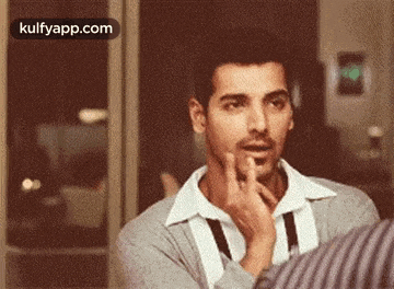a man is making a funny face while talking to another man .