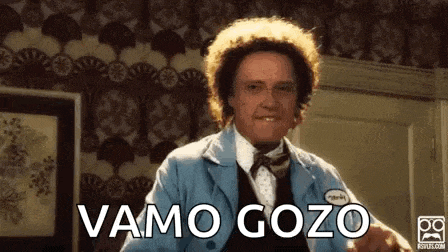 a man with curly hair is wearing a blue jacket and a bow tie and says vamos gozo .