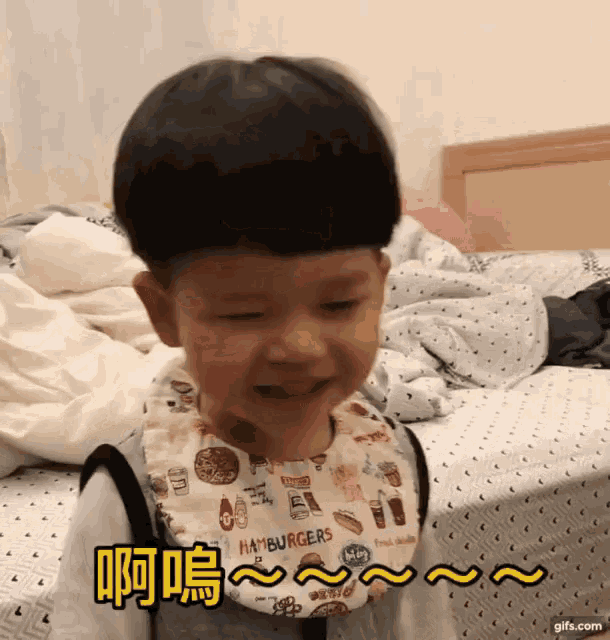 a little boy wearing a bib that says hamburgers