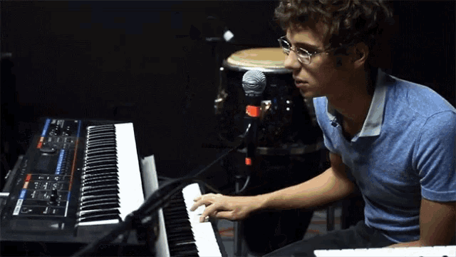a young man is playing a keyboard in front of a drum set
