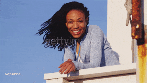 a woman leaning on a railing with the number 562283333 on the bottom