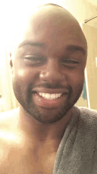 a man with a towel around his neck smiles for the camera