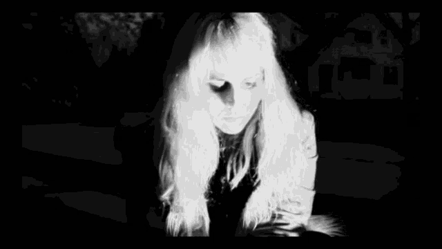 a black and white photo of a woman with long blonde hair .
