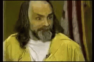 a man with long hair and a beard in a yellow jacket