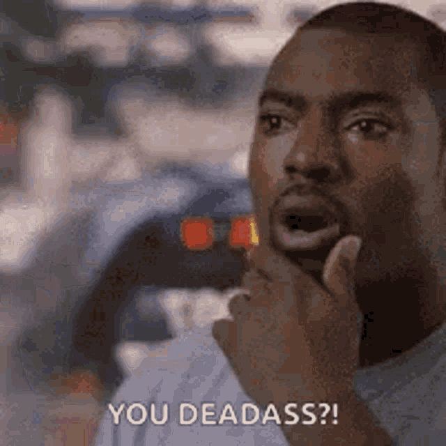 a man is holding his hand to his chin and says `` you dead ass '' .