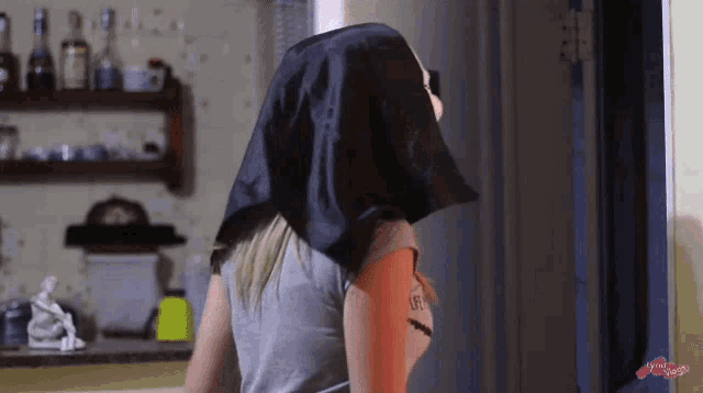 a woman wearing a black scarf on her head with the word life on her arm