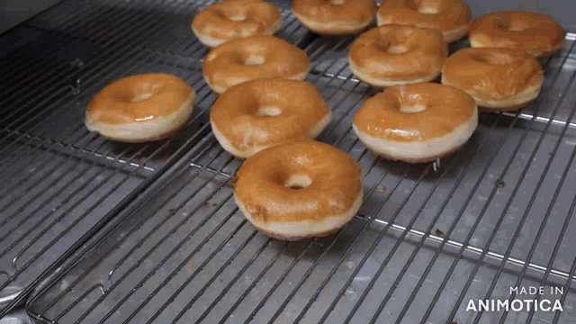 a bunch of donuts are sitting on a cooling rack with the words made in animotica on the bottom
