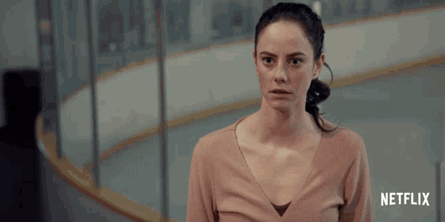 a woman stands in front of an ice rink with netflix written on the bottom