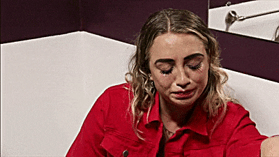 a woman in a red jacket is sitting in a bathtub .