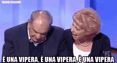a man and a woman are sitting next to each other and the woman is saying e una vipera
