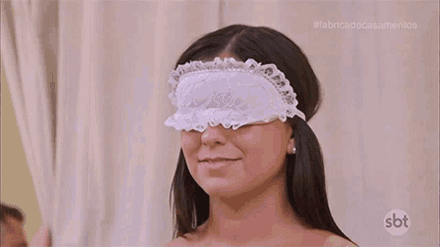 a woman is wearing a blindfold over her eyes .