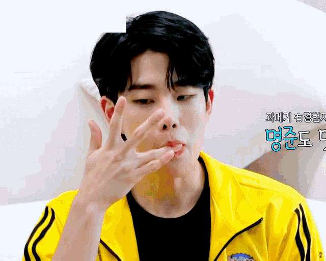 a man wearing a yellow jacket with black stripes on the sleeves is making a funny face
